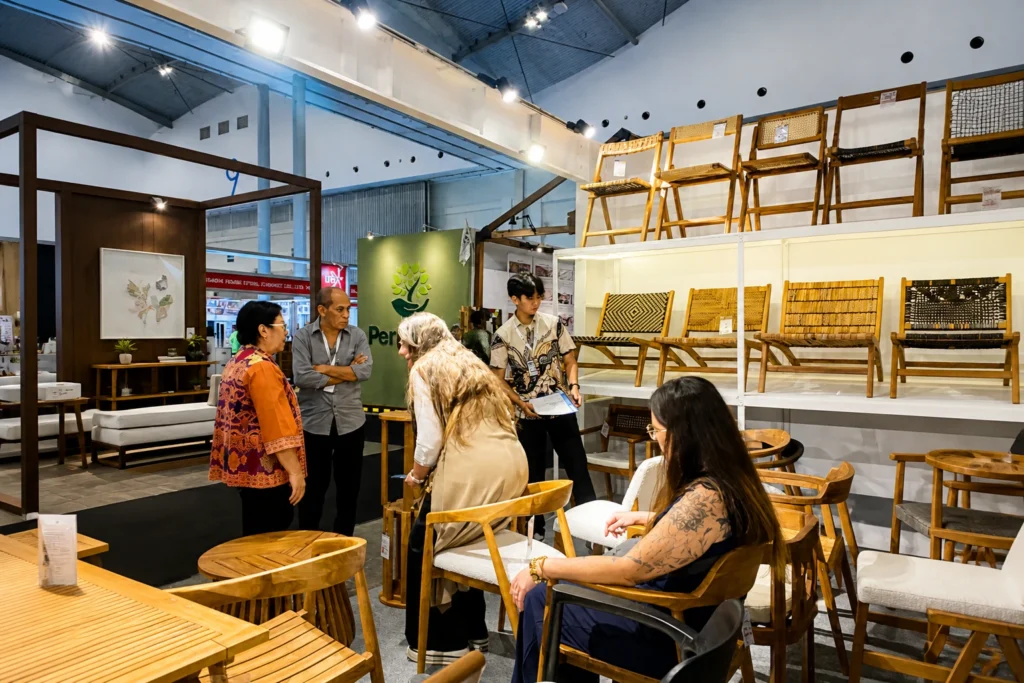 International visitors exploring handcrafted teak furniture at Euroindo Jaya exhibition booth in Indonesia