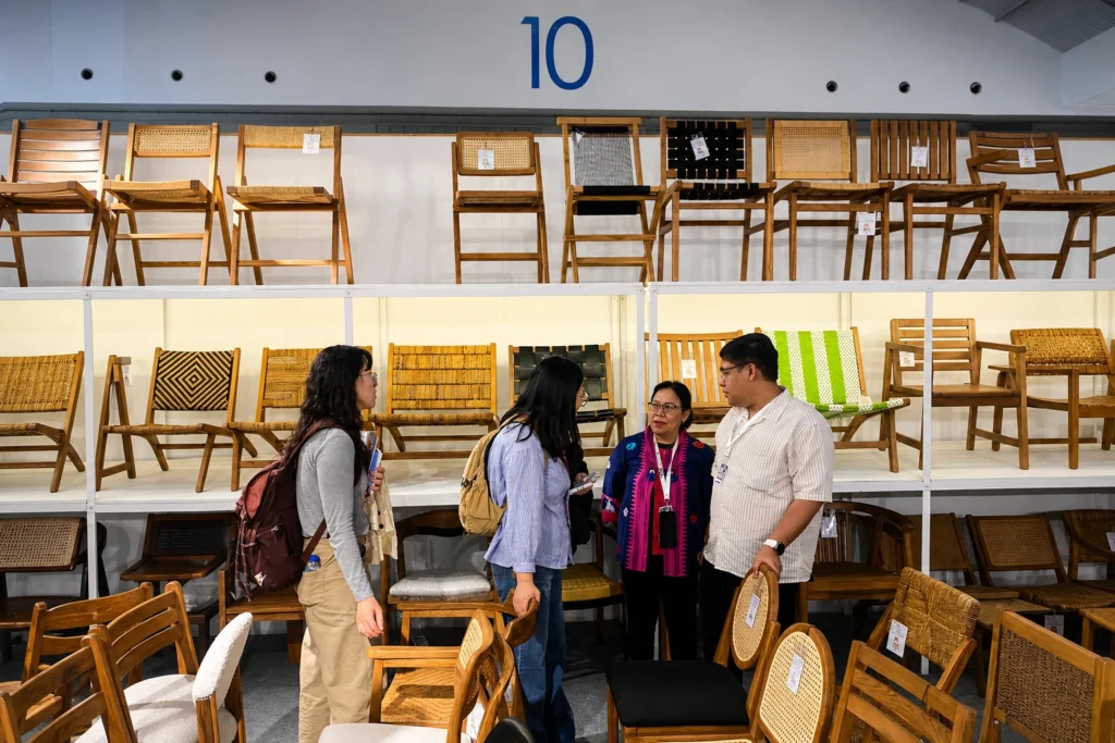 International furniture buyers reviewing handcrafted chair collections at Euroindo Jaya exhibition booth